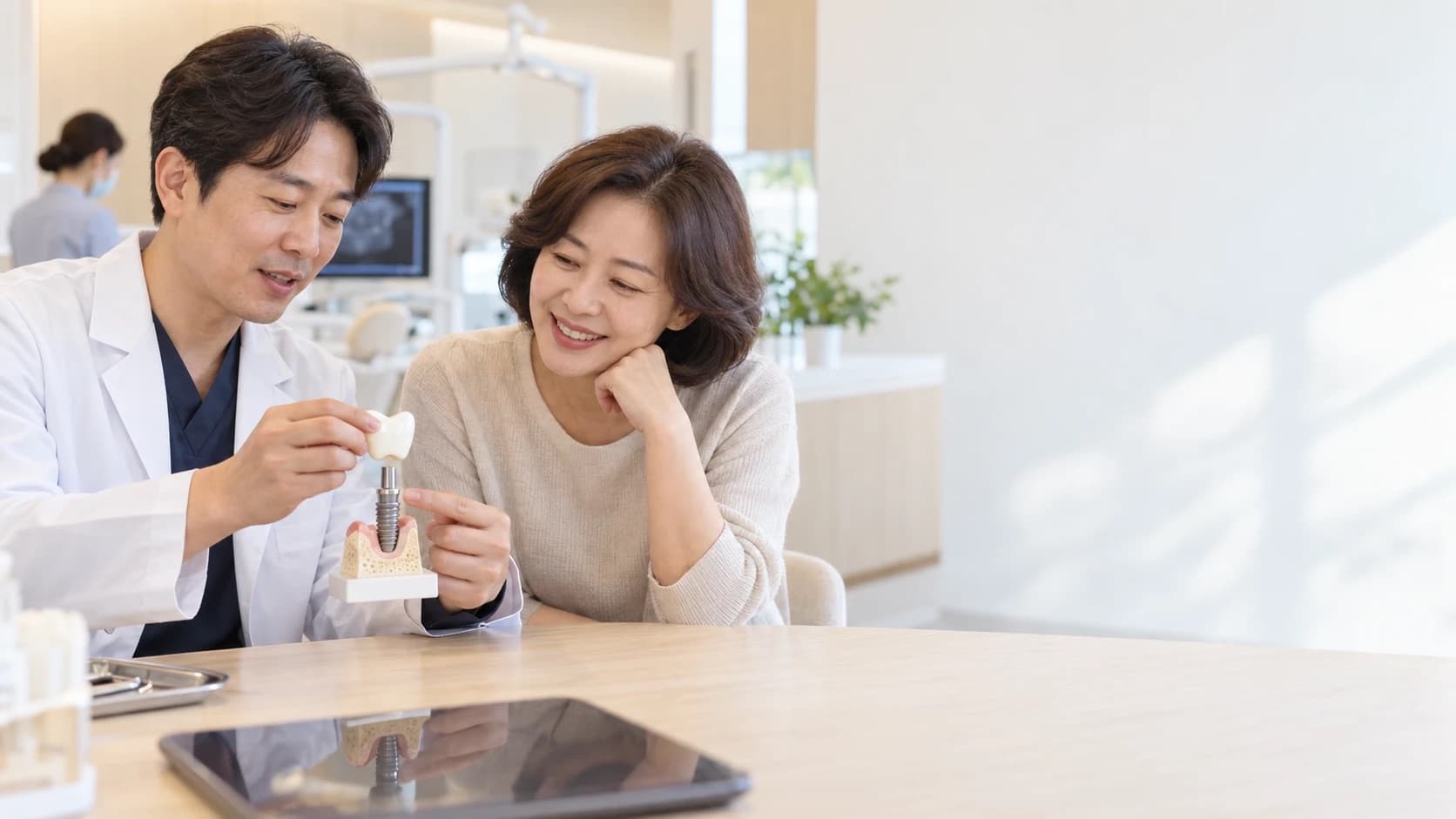 A dentist explaining an implant X-ray to a patient at a dental clinic in Uijeongbu.